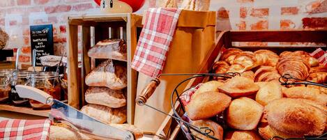 A bakery display with various breads and pastries, a knife, and a red mushroom decoration.