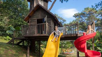 A wooden play structure with a yellow slide and a red spiral slide.