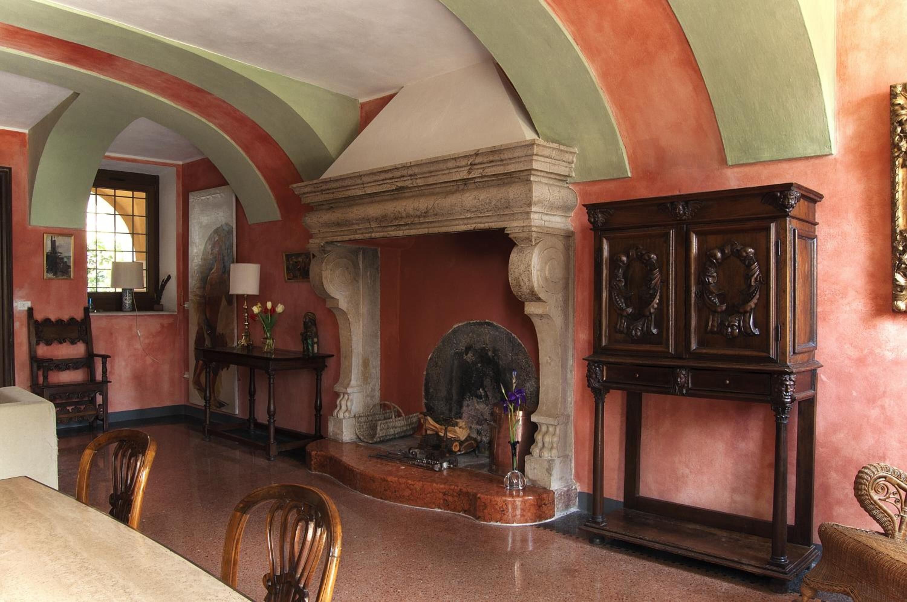 Una habitación con chimenea, muebles de madera y repisa de piedra.