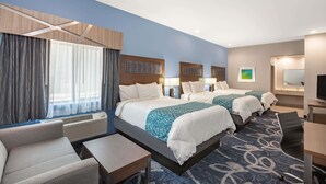 A hotel room with two beds, a desk, a chair, and a large window with curtains. - Baymont by Wyndham Houston Hobby Airport (Houston)