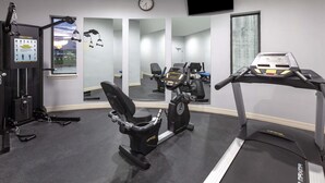 A gym with cardio equipment, weight machines, and mirrors. - Baymont by Wyndham Houston Hobby Airport (Houston)