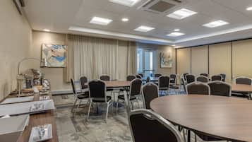 Una sala de conferencias con una larga mesa, múltiples sillas y un ventanal amplio.