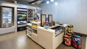 A store with a refrigerated section, a chilled section, and a counter with snacks and beverages.