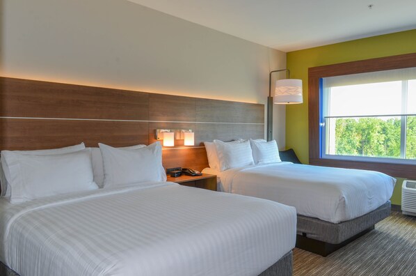 A hotel room with two beds, a nightstand with a lamp, and a window with a view of trees. - Holiday Inn Express & Suites Raleigh Airport - Brier Creek by IHG (Raleigh)