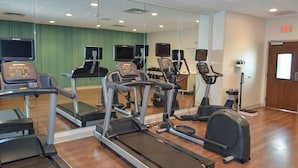 A gym with treadmills, elliptical machines, and exercise bikes.