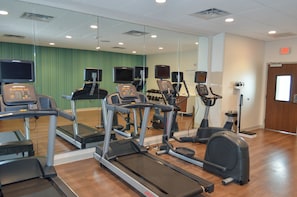 A gym with treadmills, elliptical machines, and exercise bikes.