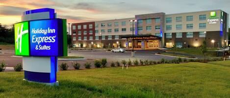 Un hotel Holiday Inn Express & Suites con un edificio moderno y un estacionamiento.