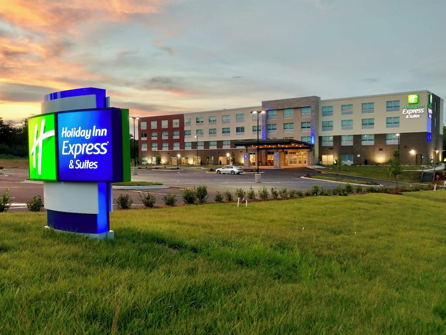 A Holiday Inn Express & Suites hotel with a modern building and a parking lot.