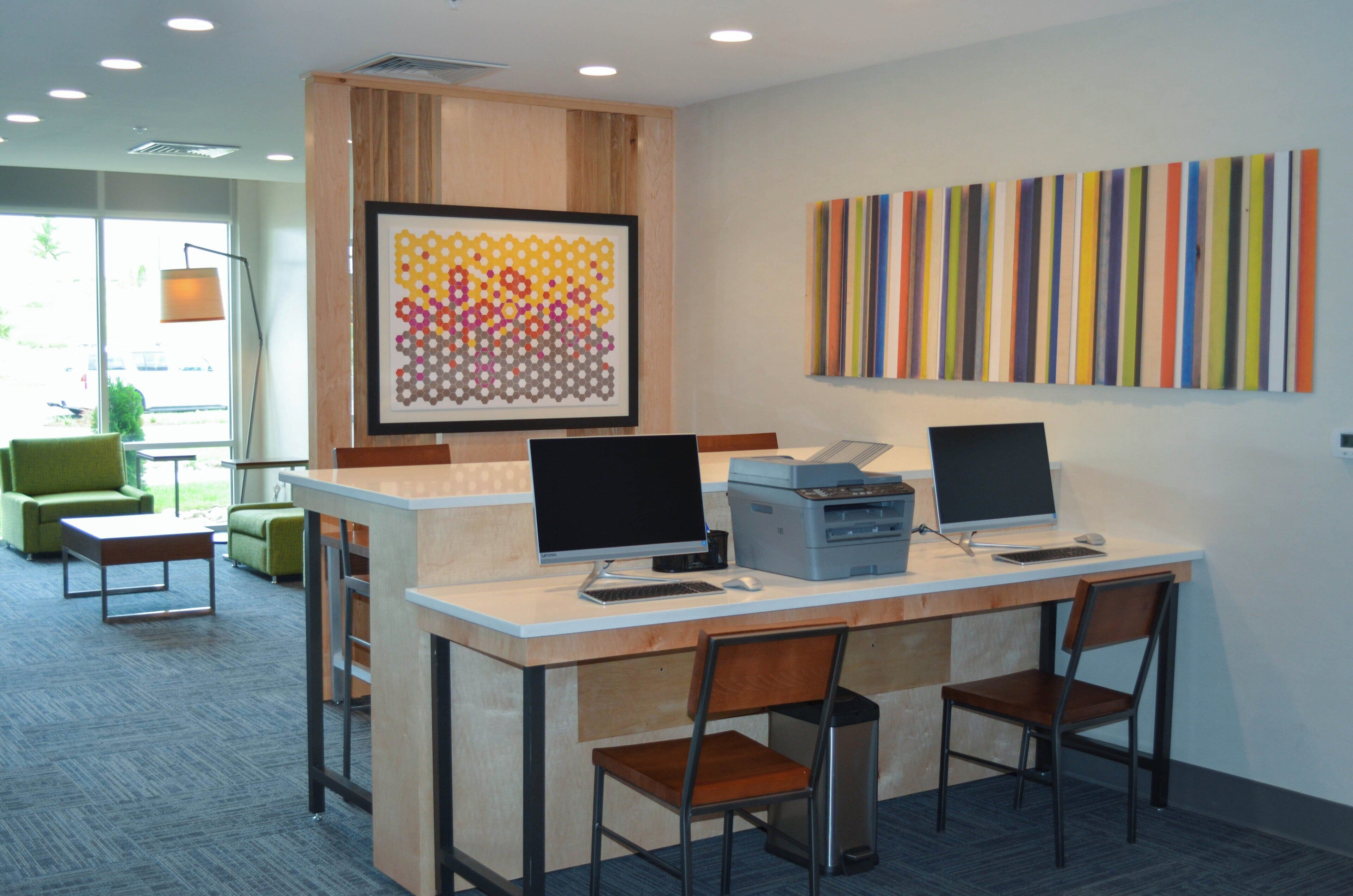 A modern office space with two desks, computers, and chairs.