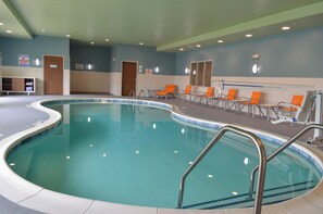 An indoor swimming pool with multiple lanes, safety railings, and lounge chairs. - Holiday Inn Express & Suites Raleigh Airport - Brier Creek by IHG (Raleigh)