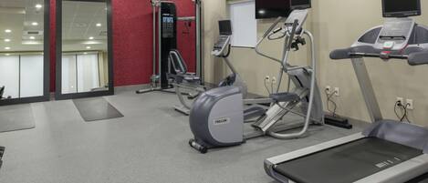 A gym with treadmills, elliptical machines, and weight equipment.