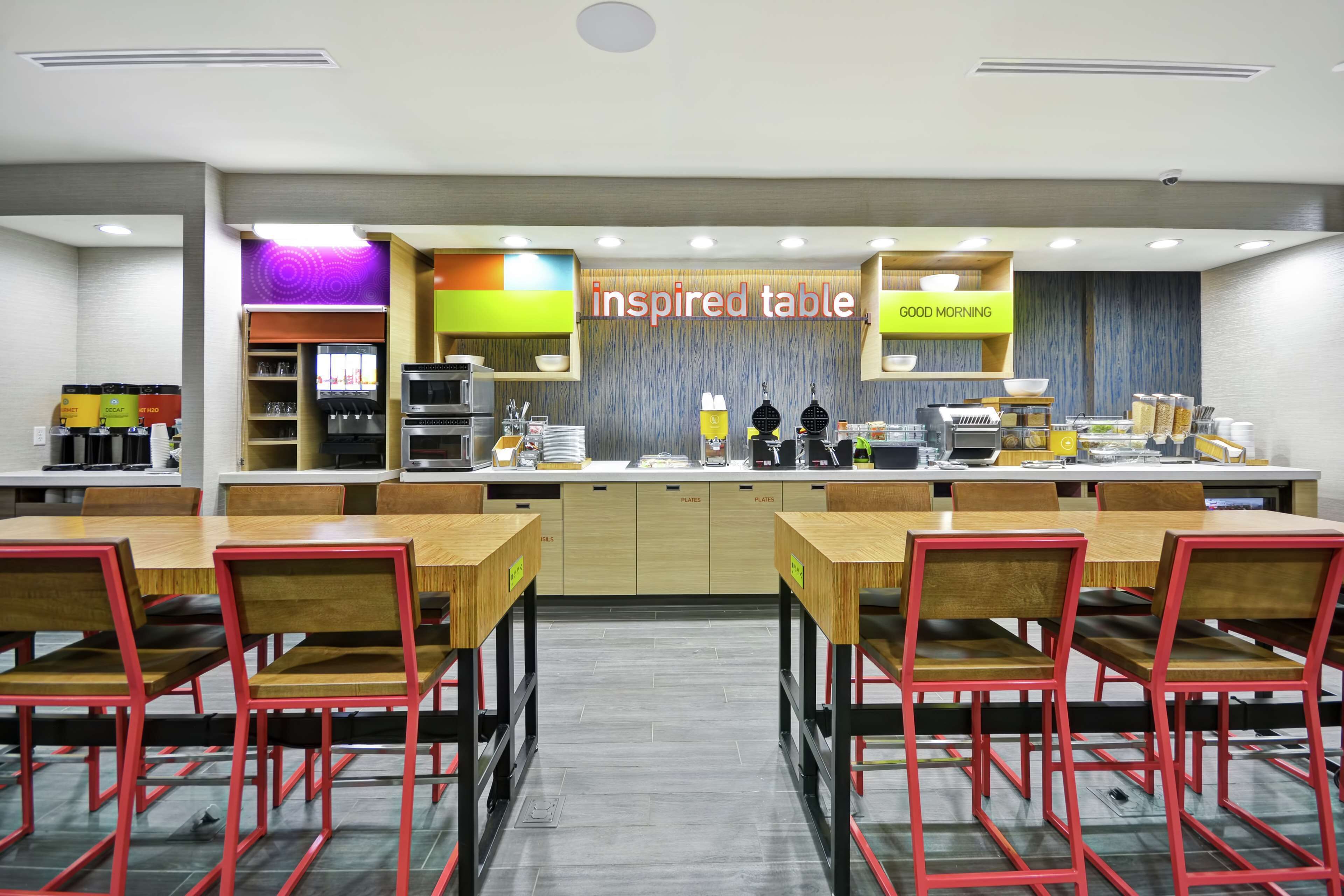 A modern kitchen with a 'GOOD MORNING' sign, a coffee station, and a 'inspired table' sign.