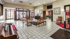 A hotel lobby with a piano, wooden benches, a red carpet, and a sign requesting the door to be kept closed. - Smart Extended Stay (Beckley)