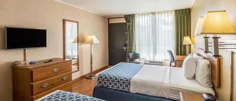 A hotel room with two beds, a TV, a desk, and a chair.