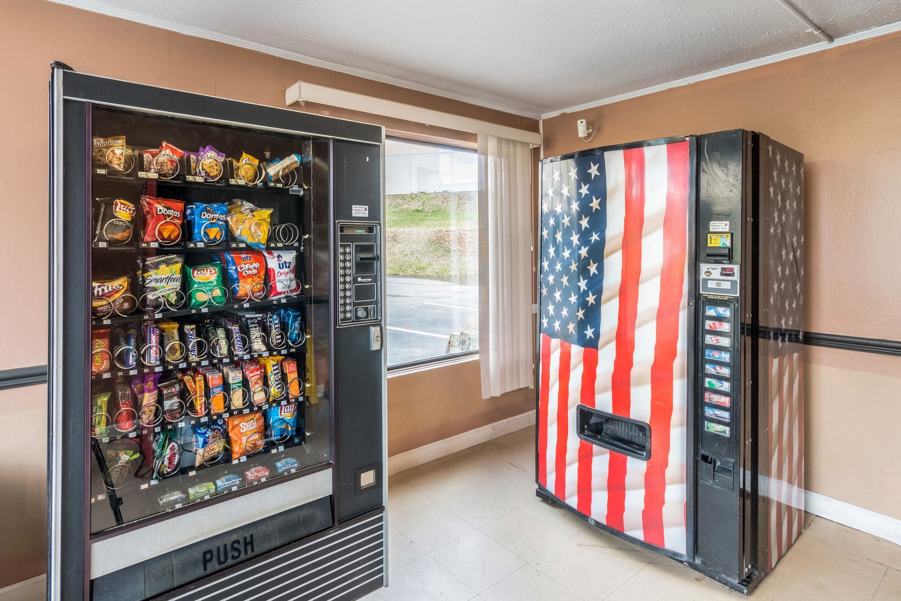 En automat med forskelligt slik og snacks samt en drikkevaremaskine, og et køleskab med et amerikansk flag-design.