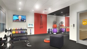Una sala de gimnàstica moderna amb equip d'exercici, una televisió que mostra notícies i un mirall que reflecteix l'espai.