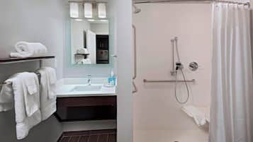 Un baño moderno con ducha, lavamanos y espejo.