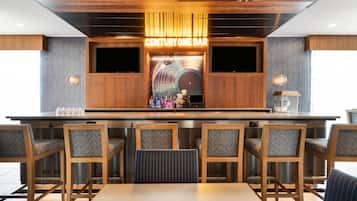 A bar area with wooden furniture and a neon sign reading 'CENTURY ONE BAR'.