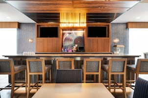 A bar area with wooden furniture and a neon sign reading 'CENTURY ONE BAR'.
