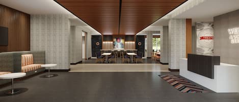 A modern lobby with a central seating area, a reception desk, and a patterned floor.