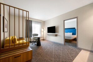 A hotel room with a bed, a TV, a desk, a chair, and a sofa. - Hampton Inn Nashville Airport Century Place, TN (Nashville)