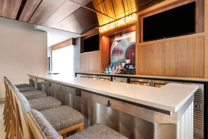 Zona de bar con mostrador, taburetes y un cartel que dice 'CENTURY ONE BAR'.