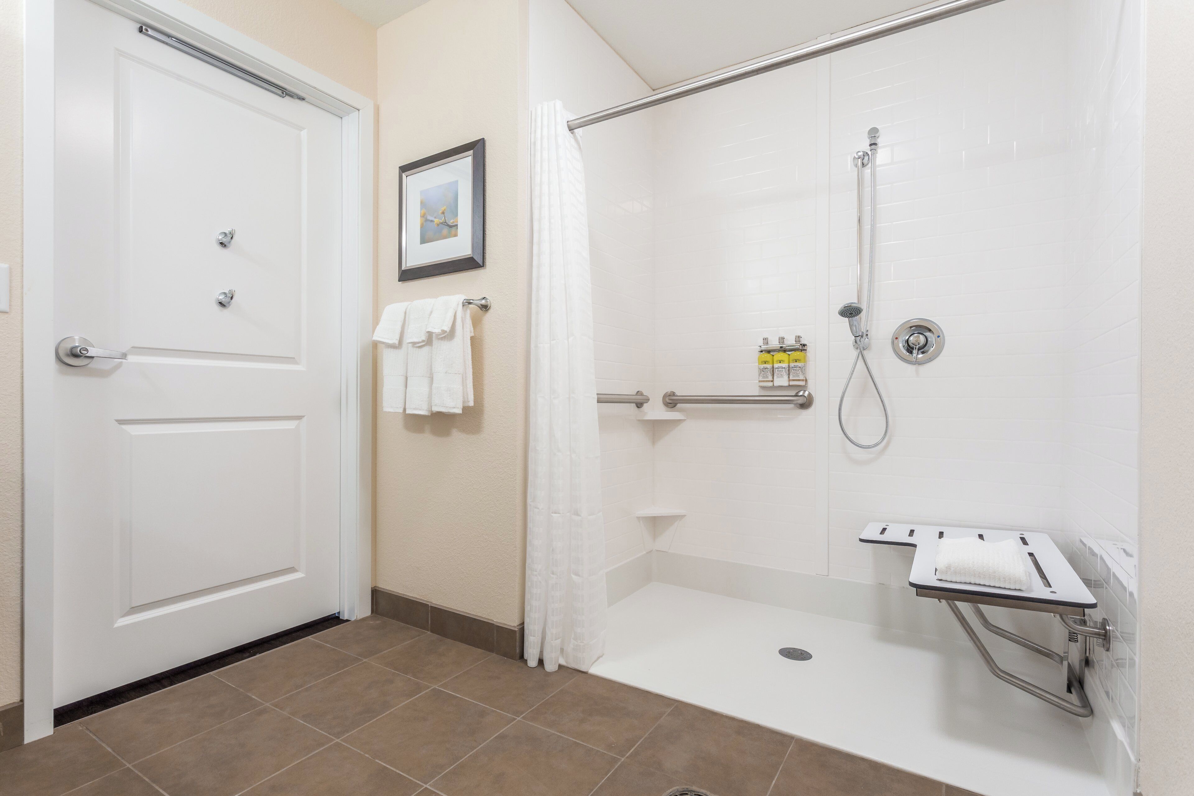 A bathroom with a shower, a toilet, and a sink.