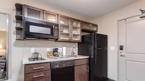 A modern kitchen with a dishwasher, microwave, and refrigerator. - Candlewood Suites Eau Claire I-94 by IHG (Eau Claire)