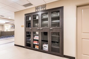 A lending locker with multiple compartments, including a fan and board games.