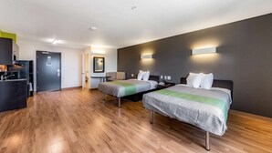 A modern hotel room with two beds, a kitchenette, and a bathroom. - Studio 6 San Marcos, TX (San Marcos)