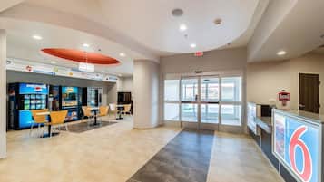A lobby with vending machines, seating area, and a reception desk.