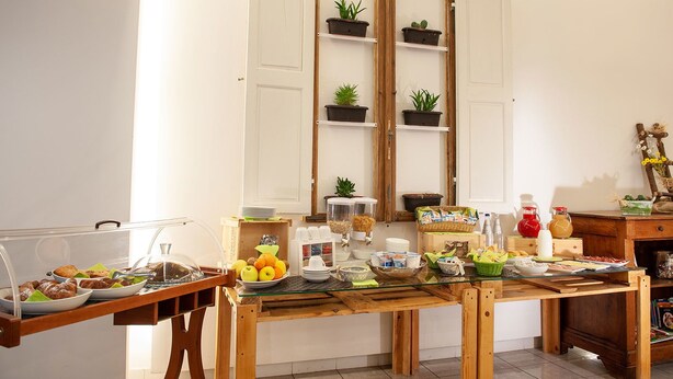 A breakfast buffet setup with various food items and drinks on a wooden table. - Hotel Portavaldera (Peccioli)