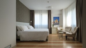 A hotel room with a bed, a desk, a chair, and a painting on the wall. - Hotel Portavaldera (Peccioli)