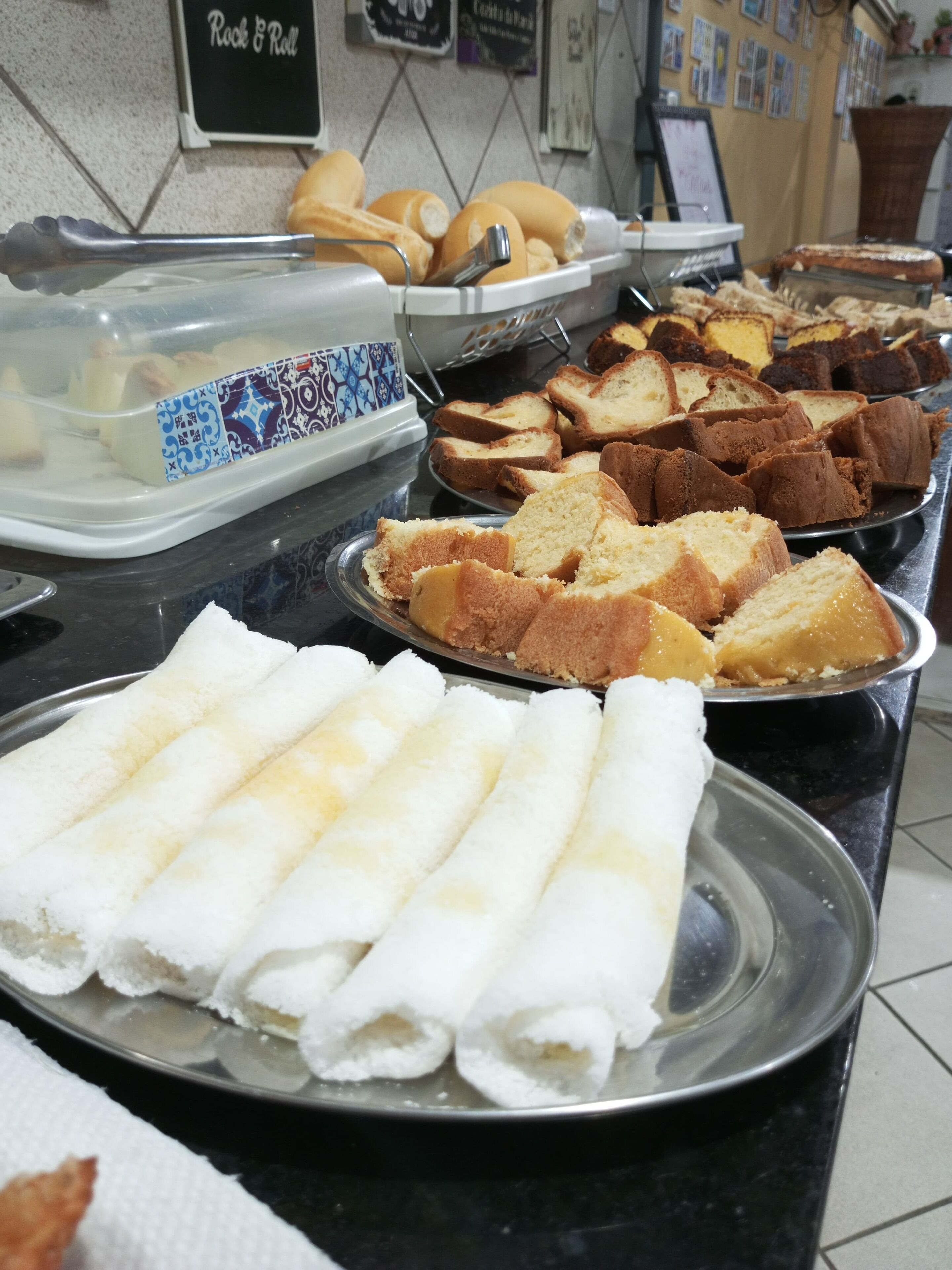 Un bufé con diferentes opciones de comida, incluyendo pan, pasteles y bollería.