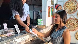 Mostrador con salpicadero de azulejos, una computadora y un cartel que indica una opción de pago.