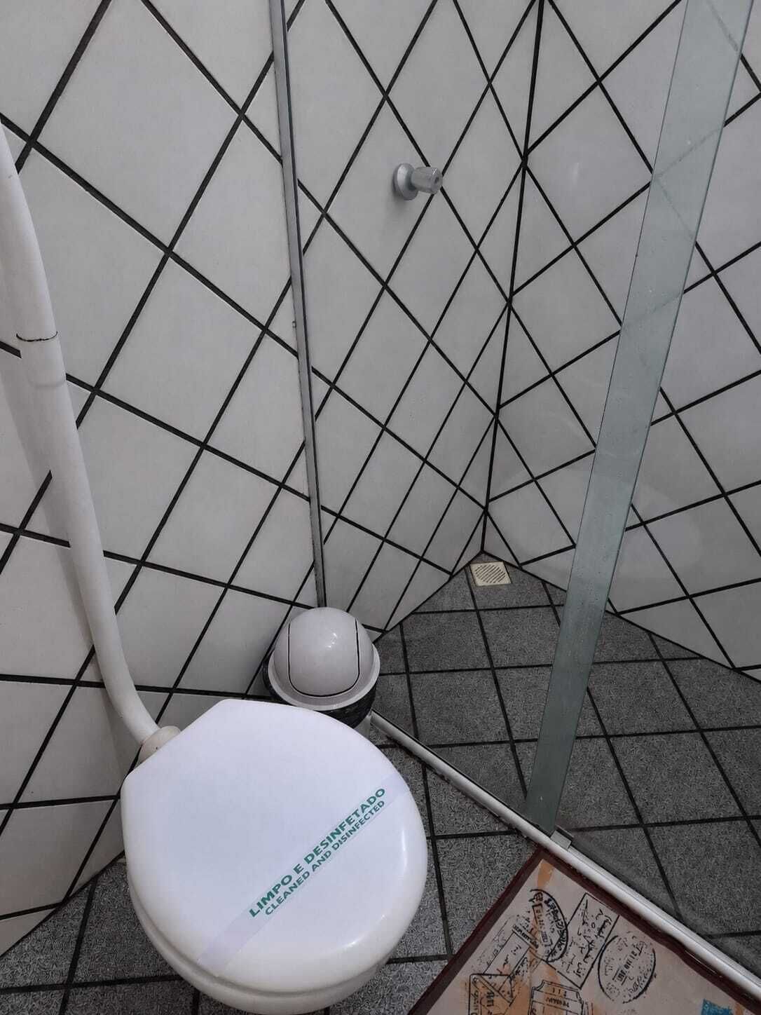 Un baño con un inodoro blanco, un lavabo blanco y piso de baldosas.