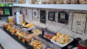 A buffet counter with various food items and condiments.