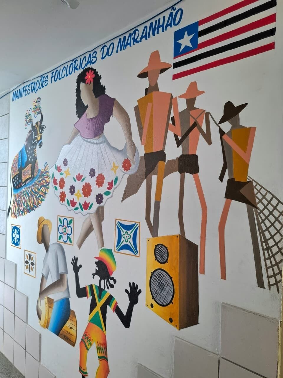 A mural with cultural figures and symbols, including a peacock, a woman in a dress, and a man with a guitar.