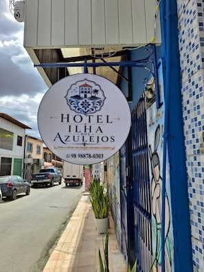 A hotel sign with a logo, name, and contact number. - Hotel Ilha dos Azulejos (São Luís)