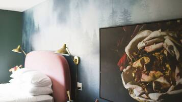 Une chambre à coucher avec un lit, un bureau, une lampe et un grand tableau encadré au mur.