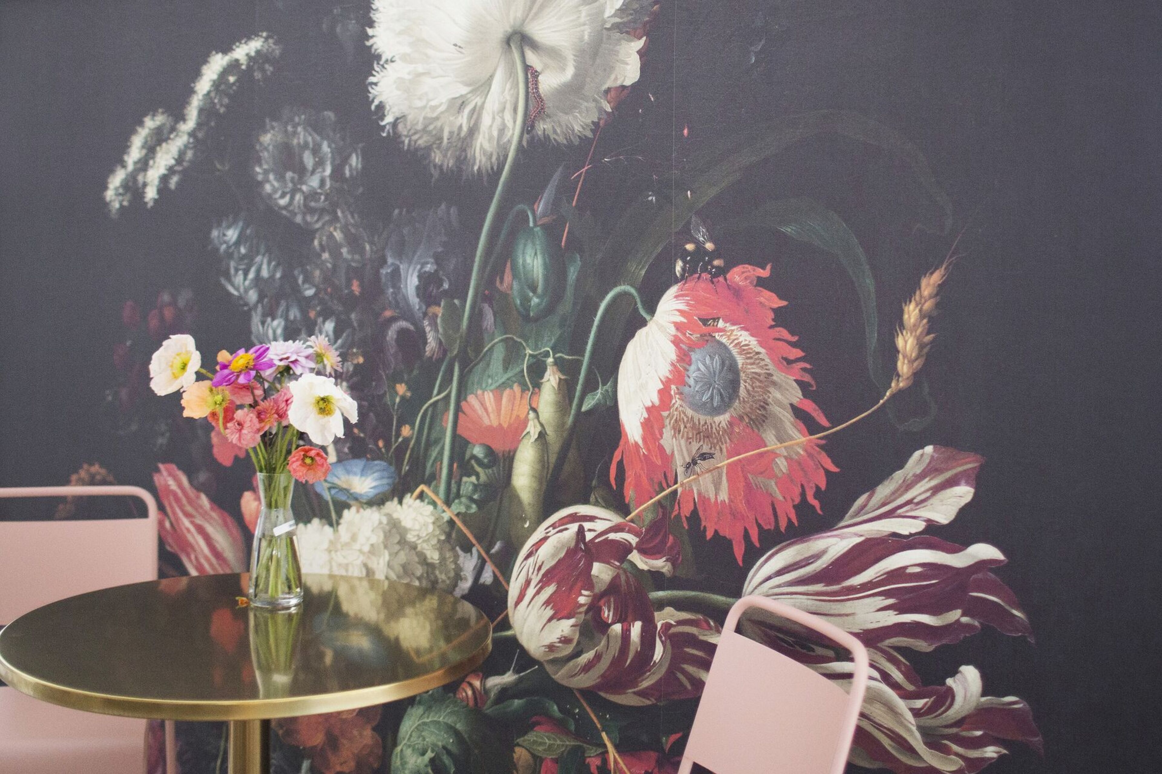 Una mesa con un jarrón de flores y un arreglo decorativo.