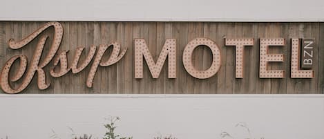 A motel sign with the name "Orville MOTEL BZN" on a wooden wall.