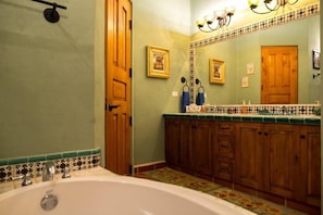 A bathroom with a bathtub, wooden cabinets, a tiled backsplash, and a mirror with wall-mounted lights. - FN395-Lovely Mexican Villa at loreto Bay (Loreto)