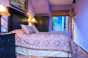 A bedroom with a bed, two bedside lamps, a dresser, and a window with a view of the outside. - FN395-Lovely Mexican Villa at loreto Bay (Loreto)