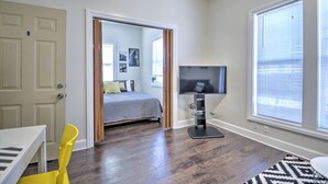 A bedroom with a bed, a TV, and a window with blinds. - Capitol Hill Apartments (Seattle)