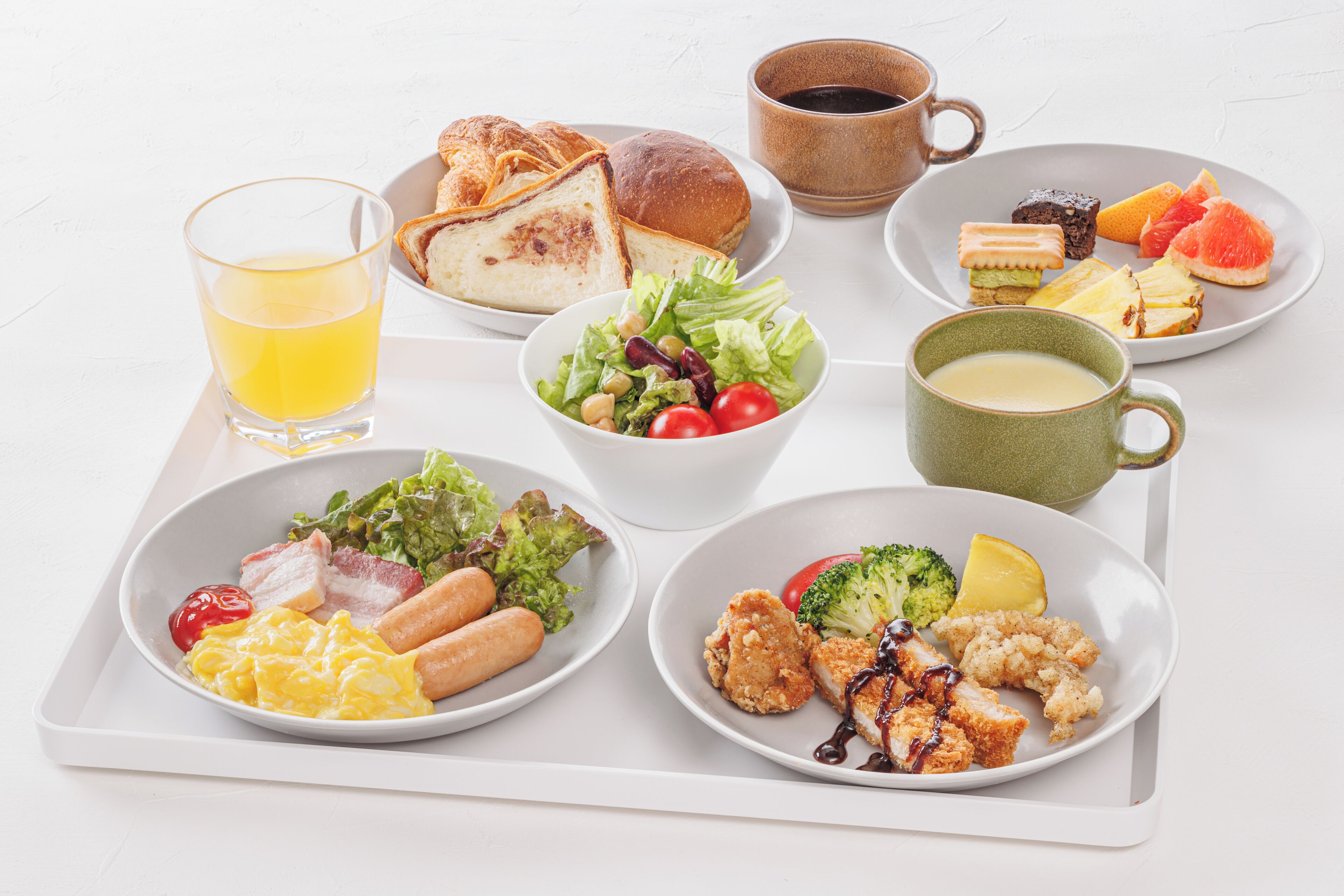 Una bandeja con diferentes opciones para el desayuno, como tostadas, una ensalada, huevos y una bebida.