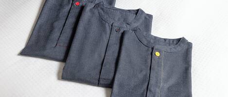 Three folded garments on a textured surface.