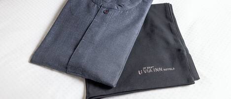 A folded garment with a visible button and a logo on the sleeve.