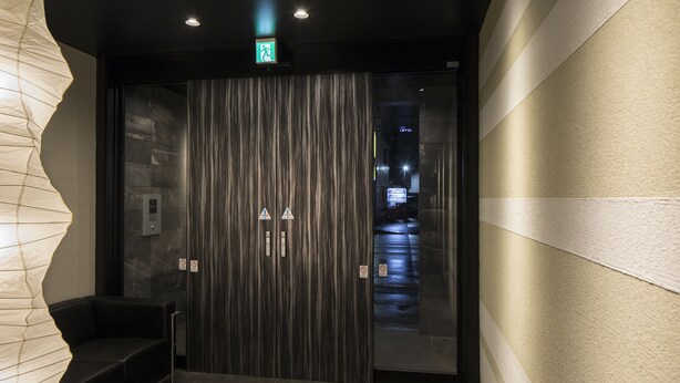 A modern elevator with a striped wall and a bench.