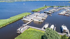A marina with multiple docked boats and floating houses.